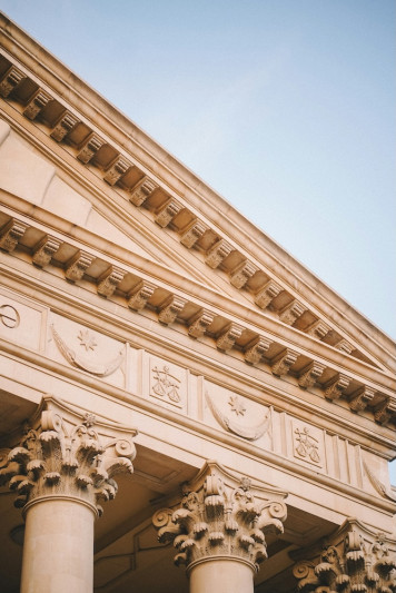 a close up of a building with columns and a clock