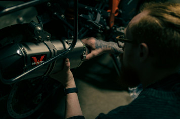 a man working on a motorcycle with a wrench