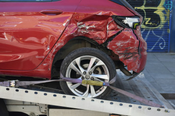 a red car is on a flatbed tow truck