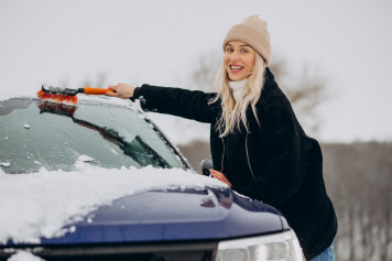 woman cleaning her window car from snow